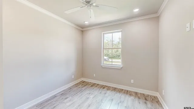 an empty room with a window and wooden floor