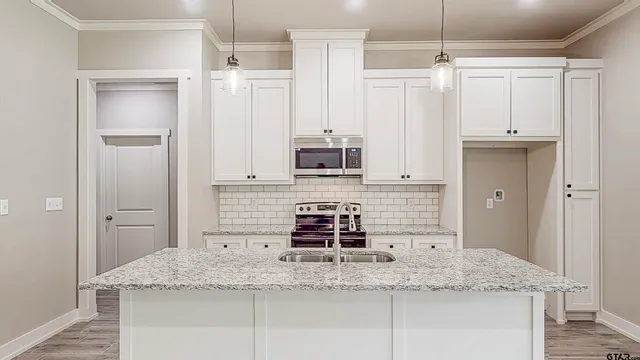 a kitchen with stainless steel appliances granite countertop a sink and a refrigerator