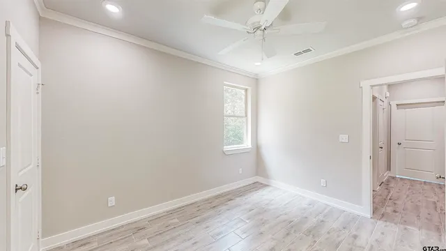 an empty room with wooden floor and window