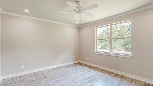 an empty room with a window and a ceiling fan