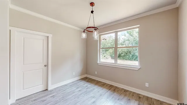 en empty room with window and wooden floor