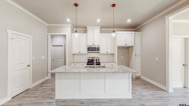 a kitchen with kitchen island a counter top space appliances and cabinets