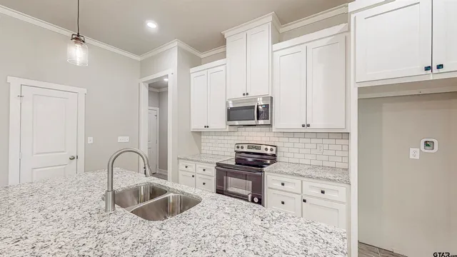 a kitchen with stainless steel appliances granite countertop a stove a sink and a microwave