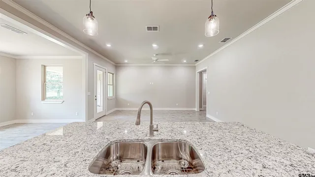 a kitchen with stainless steel appliances granite countertop a sink window and cabinets