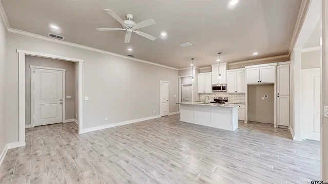 a large kitchen with kitchen island a sink stainless steel appliances and cabinets