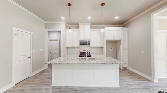 a kitchen with kitchen island white cabinets and stainless steel appliances