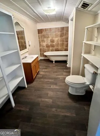 a bathroom with a sink a toilet a mirror and shower