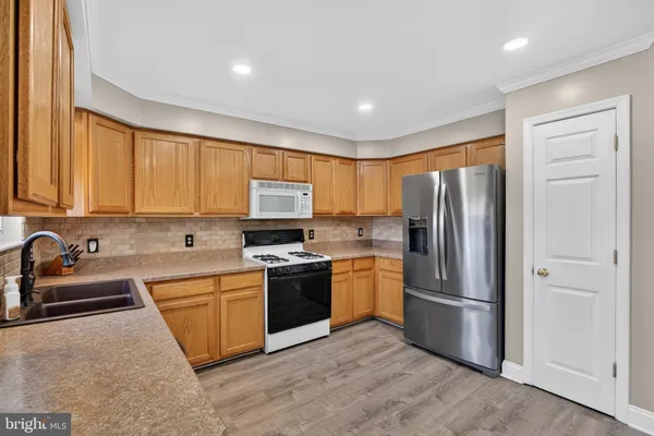 a kitchen with stainless steel appliances granite countertop a refrigerator stove and sink