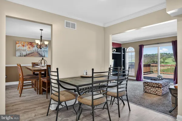 a kitchen with stainless steel appliances granite countertop wooden cabinets a dining table and chairs