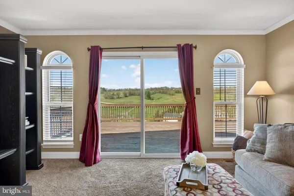 a living room with furniture a flat screen tv and a large window