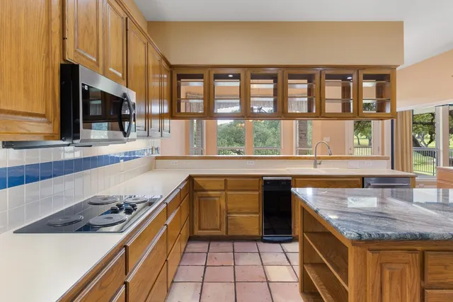 a kitchen with stainless steel appliances granite countertop a sink and a stove