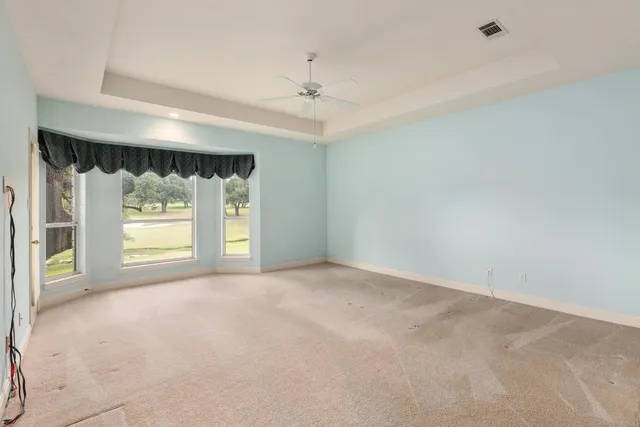 a view of an empty room with a ceiling fan