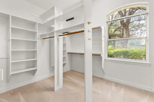 an empty room with a bathroom and a window