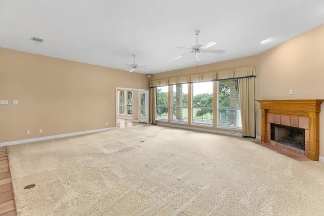 a view of an empty room with a fireplace and a large window