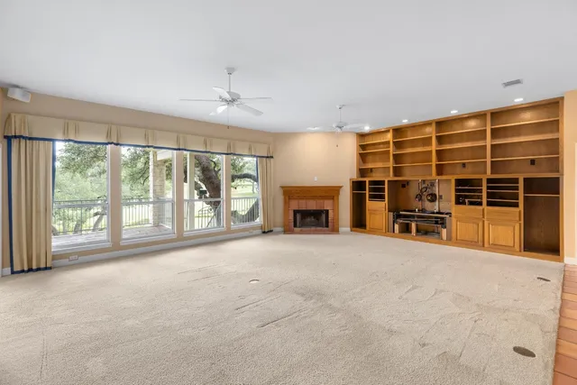 a view of an empty room with a window and fire place