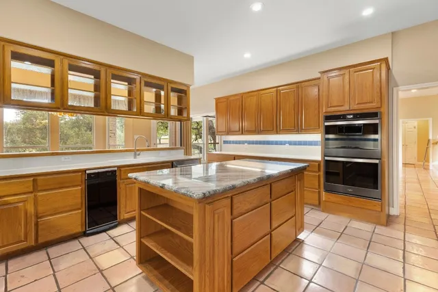 a kitchen with stainless steel appliances granite countertop a stove a sink and a refrigerator