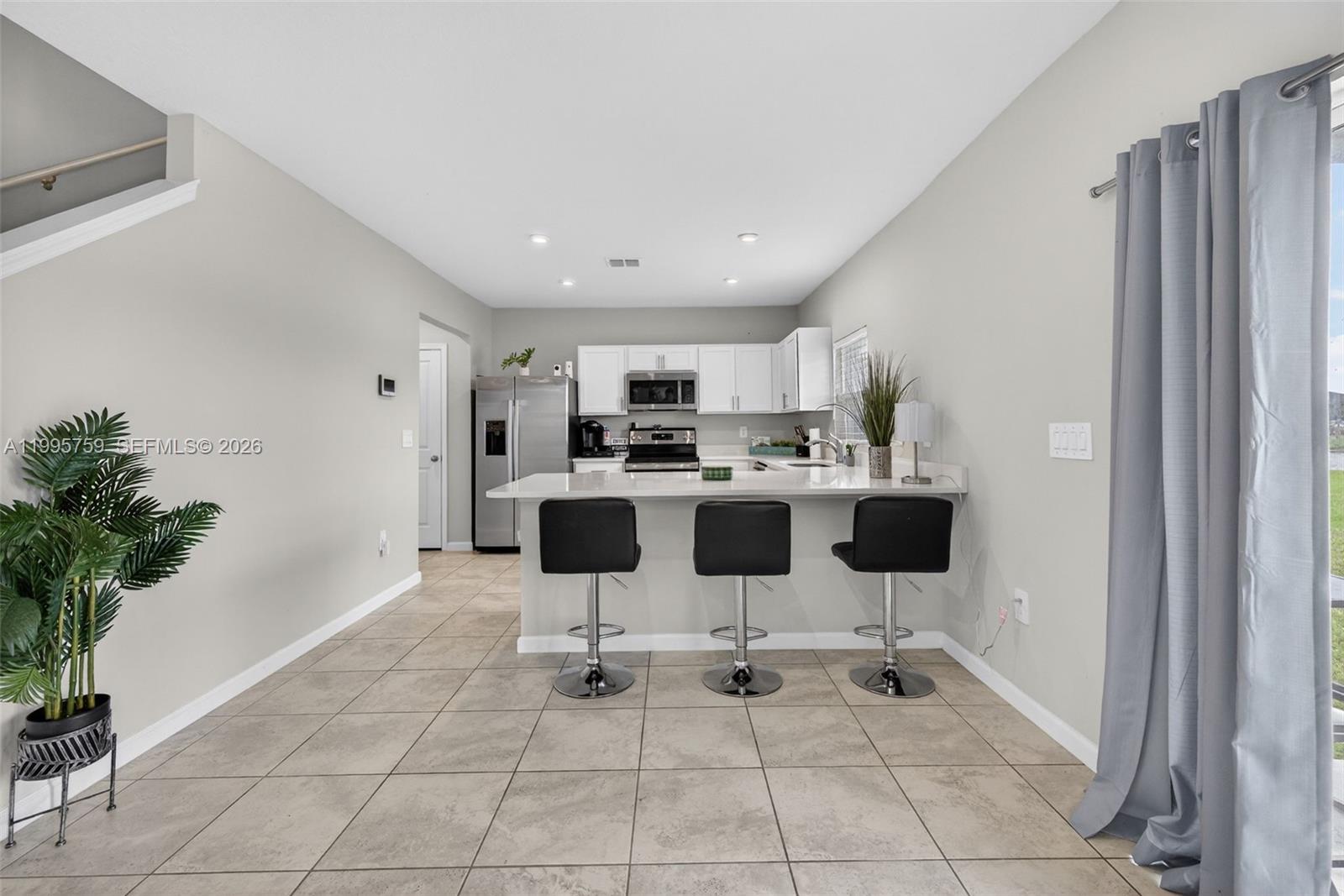 220 Raspberry Road Fort Pierce, FL 34981 - Photo 12 of 43 a kitchen with stainless steel appliances kitchen island granite countertop a refrigerator and a sink