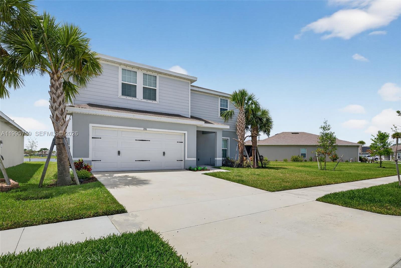 220 Raspberry Road Fort Pierce, FL 34981 - Photo 2 of 43 a front view of a house with a yard and a garage