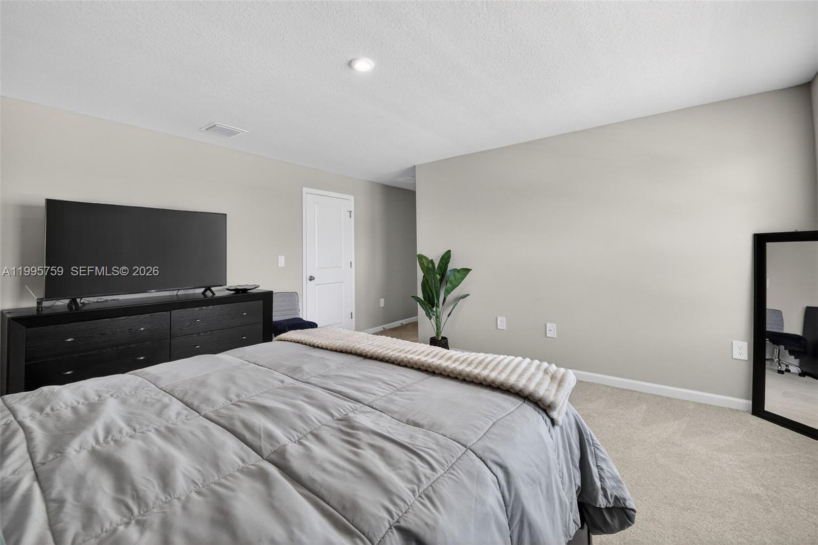 220 Raspberry Road Fort Pierce, FL 34981 - Photo 24 of 43 a bedroom with a bed and a flat screen tv