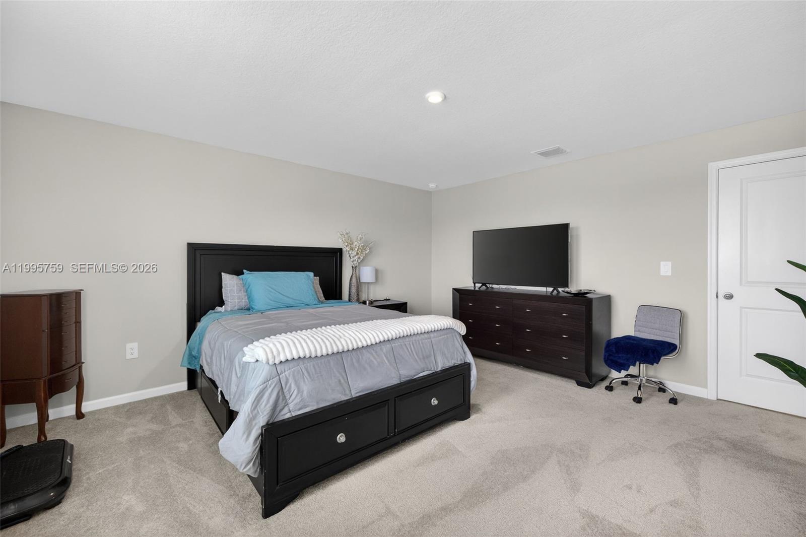 220 Raspberry Road Fort Pierce, FL 34981 - Photo 25 of 43 a bedroom with a bed and a flat screen tv