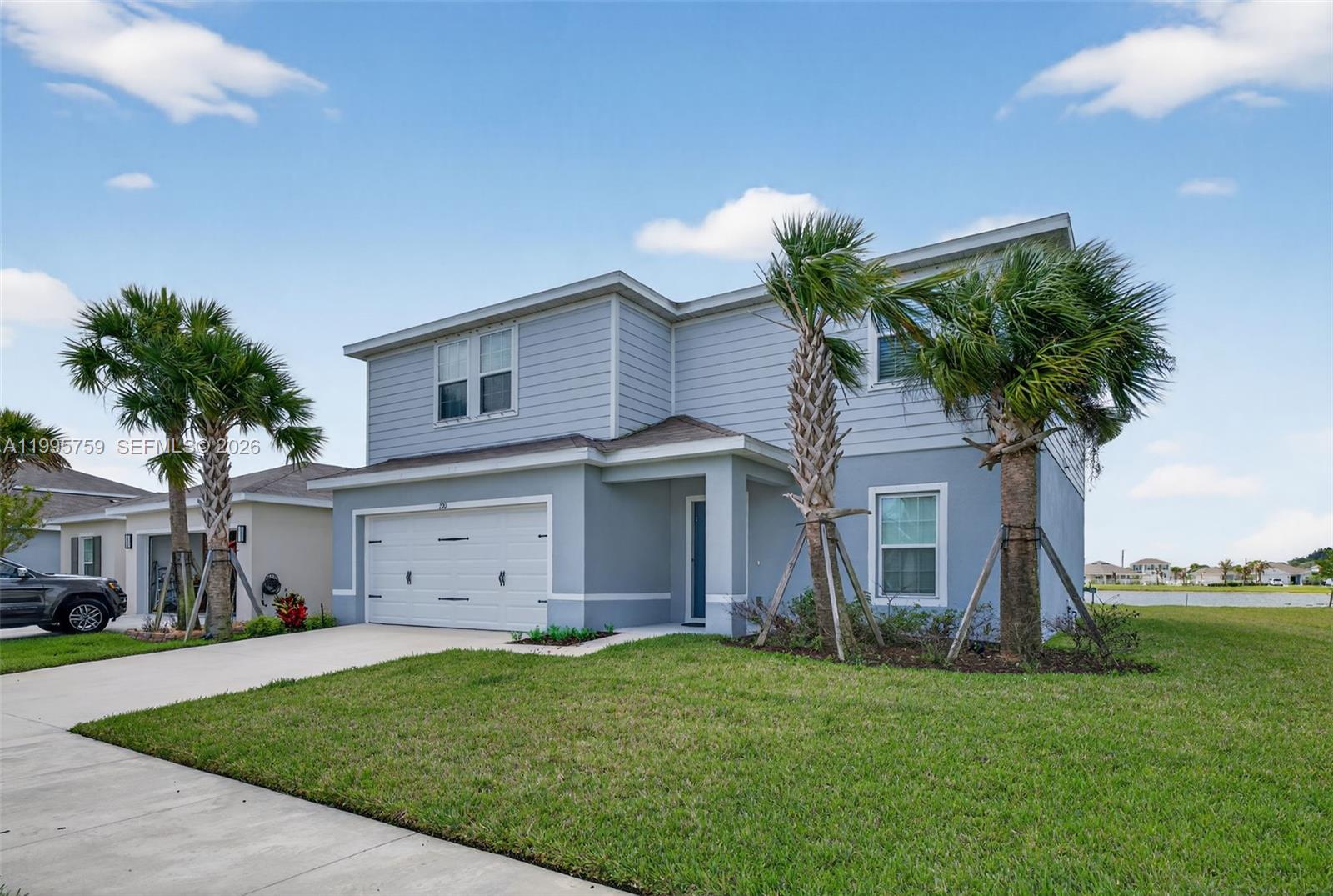 220 Raspberry Road Fort Pierce, FL 34981 - Photo 3 of 43 a front view of a house with a garden and trees