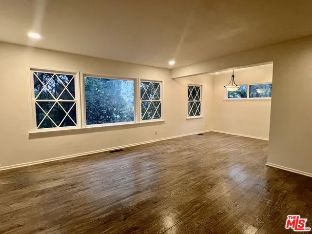 an empty room with wooden floor and staircase