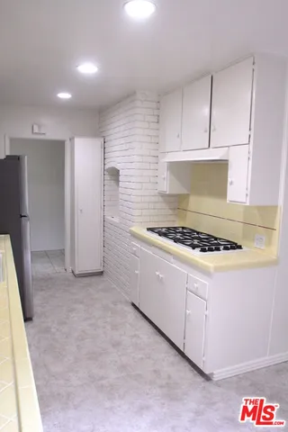 a kitchen with stainless steel appliances a sink a stove and cabinets