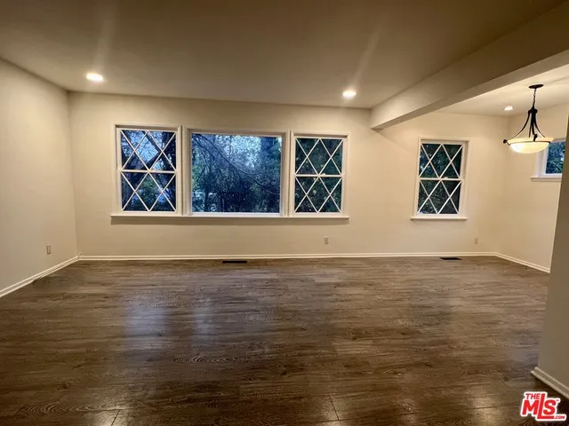 an empty room with wooden floor and fireplace