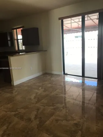 a view of a livingroom with an empty space and a window
