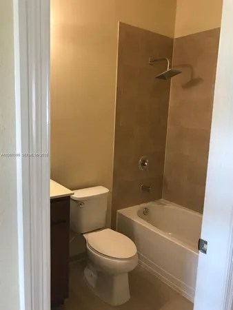 a white toilet sitting next to a bath tub