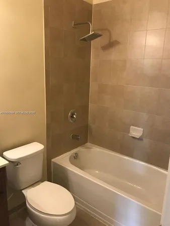 a white toilet and tub sitting next to a bathroom sink