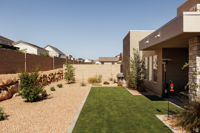 629 Spring Lily Drive St. George, UT 84790 - Photo 39 of 50 Backyard featuring a synthetic lawn, gravel landscaping, and a rock retaining wall