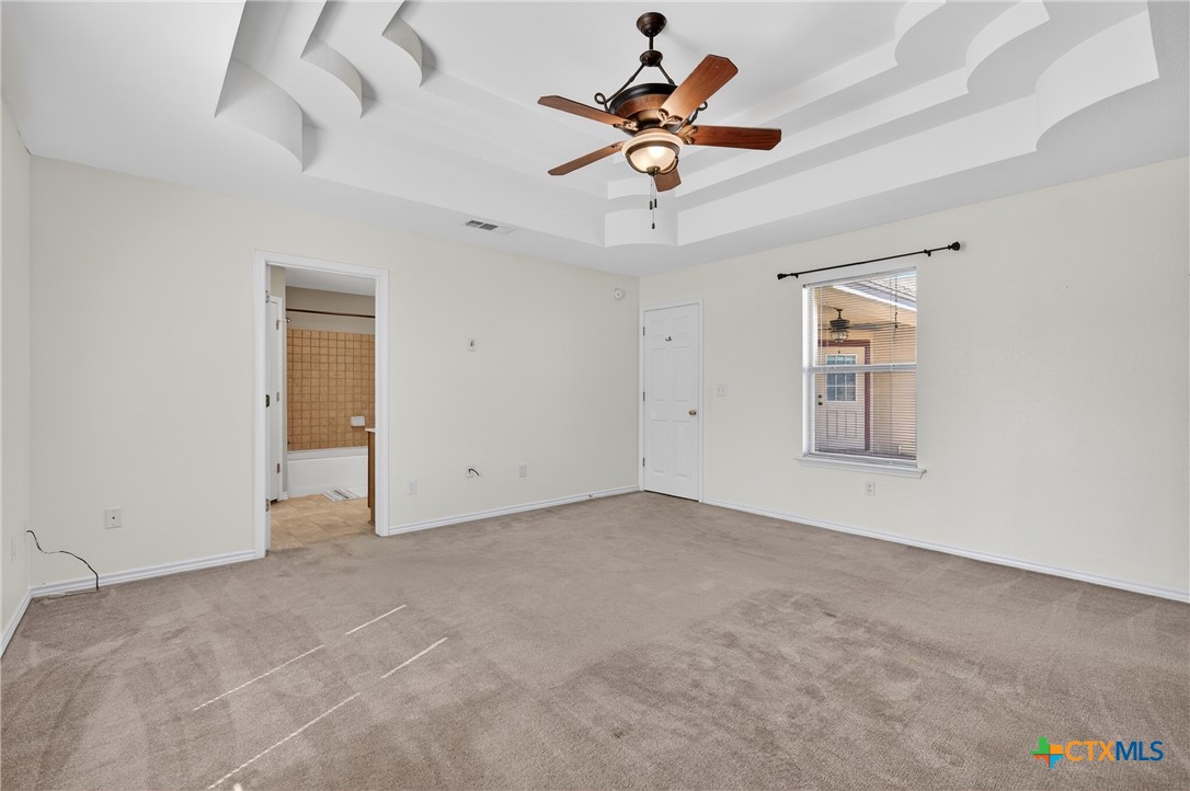 8407 Shaw Road Rogers, TX 76569 - Photo 16 of 25 an empty room with chandelier fan and windows