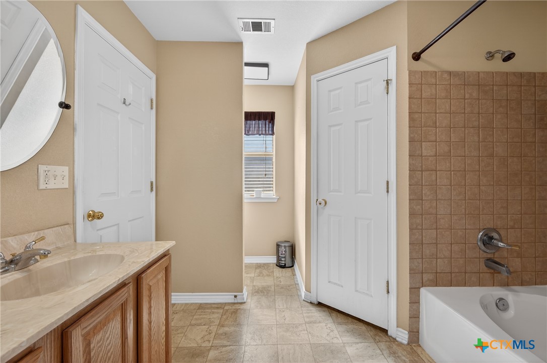 8407 Shaw Road Rogers, TX 76569 - Photo 18 of 25 a bathroom with a tub sink and mirror