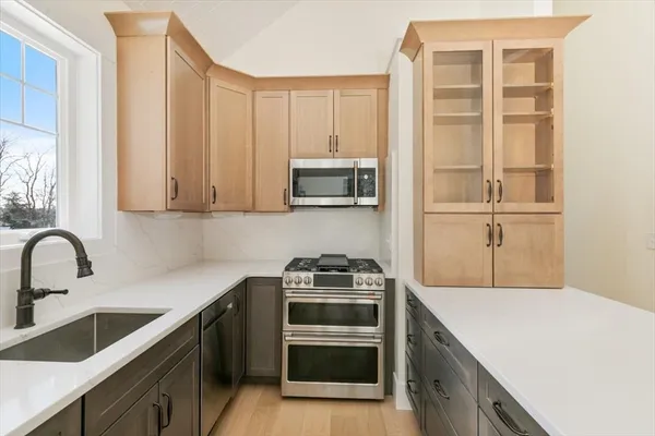 a kitchen with a sink and a stove top oven with wooden floor