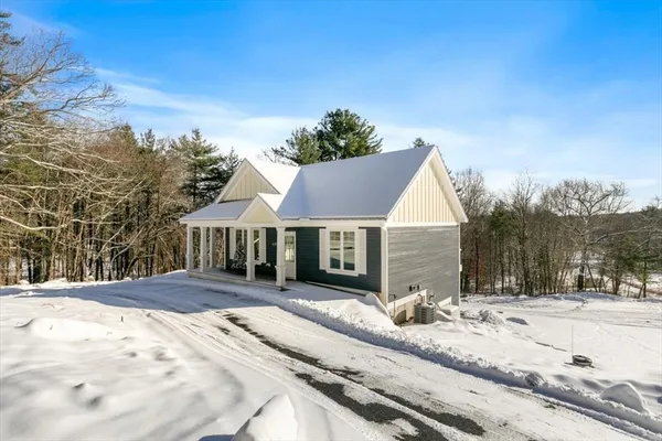 a view of a house with a yard covered in snow