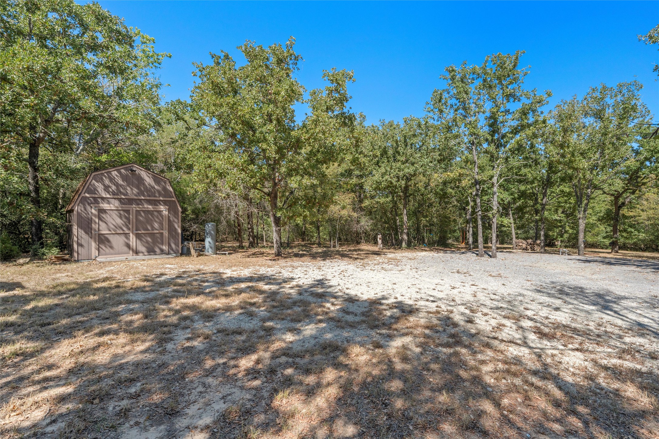 19597 Staceys Lndg Road Thornton, TX 76687 - Photo 6 of 13 a backyard of a house with large trees