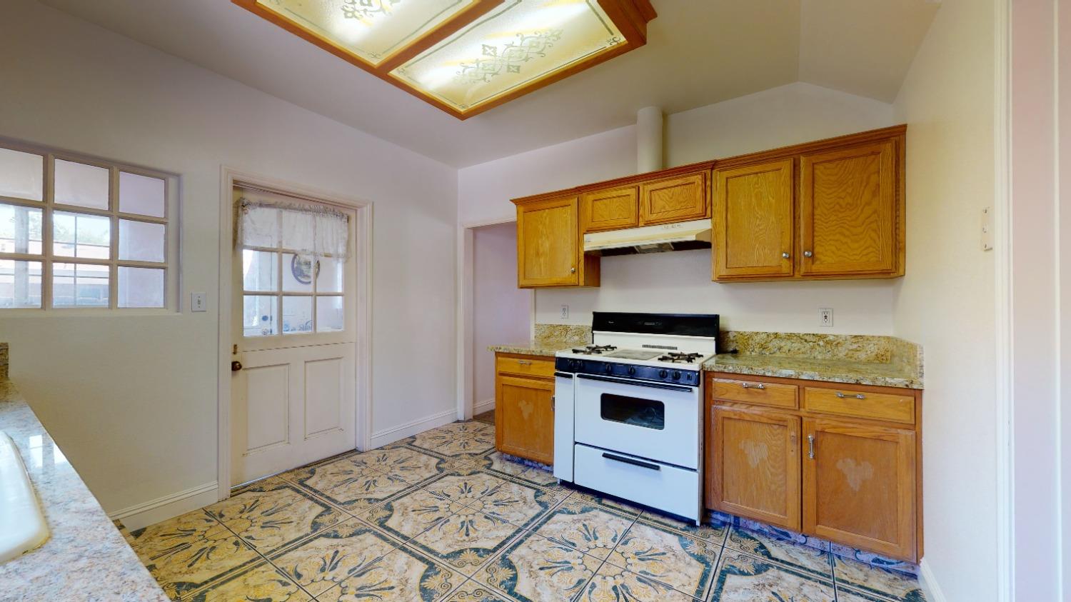 926 North Frankwood Avenue Reedley, CA 93654 - Photo 13 of 32 a kitchen with stainless steel appliances granite countertop a stove a sink and a refrigerator