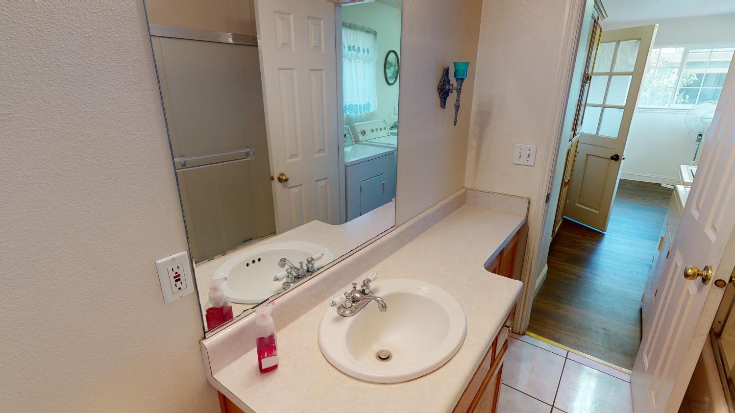 926 North Frankwood Avenue Reedley, CA 93654 - Photo 16 of 32 a bathroom with a sink and mirror with toilet