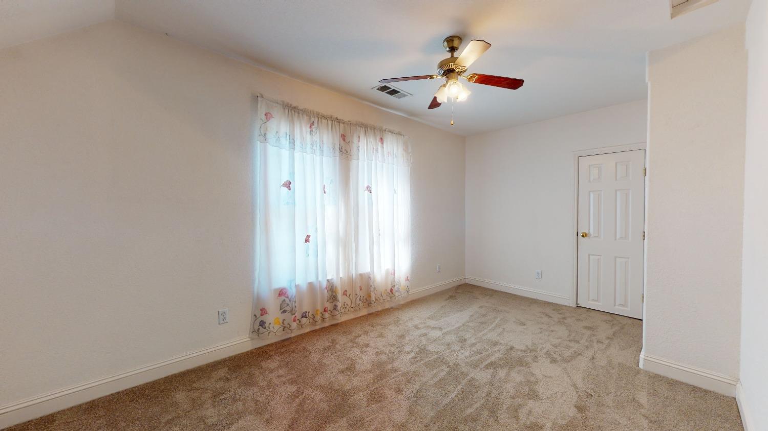 926 North Frankwood Avenue Reedley, CA 93654 - Photo 21 of 32 an empty room with chandelier fan and windows