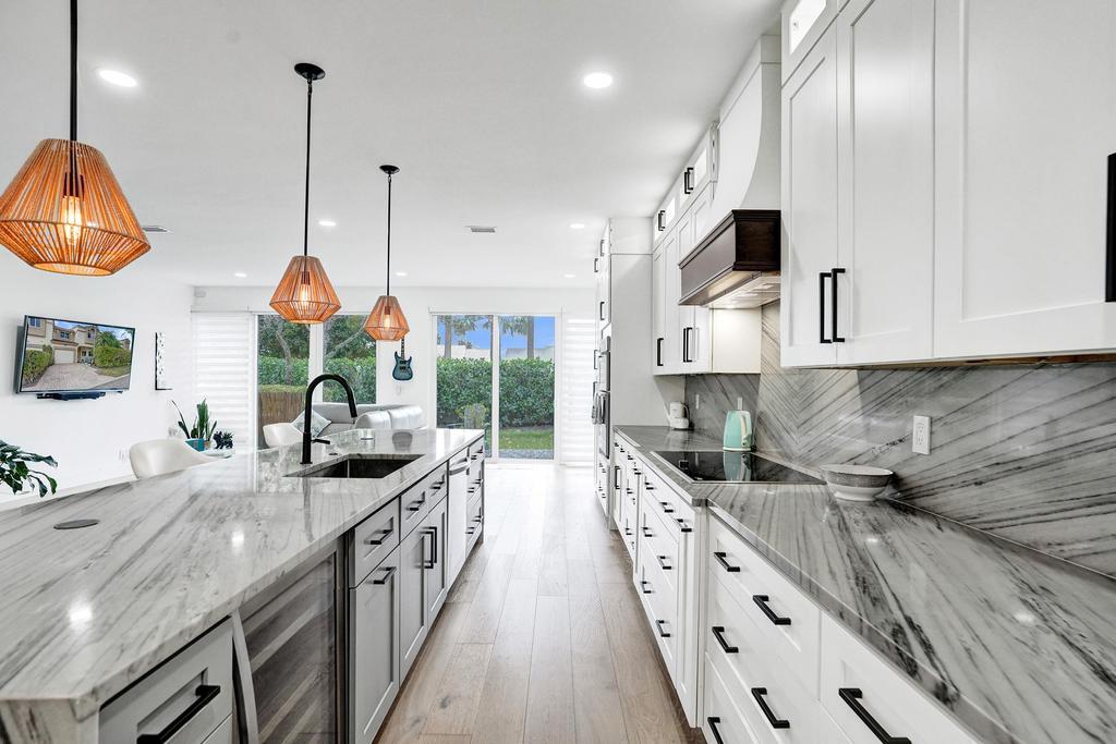 6800 Via Regina Boca Raton, FL 33433 - Photo 11 of 58 a kitchen with stainless steel appliances granite countertop a sink a stove and a wooden floors