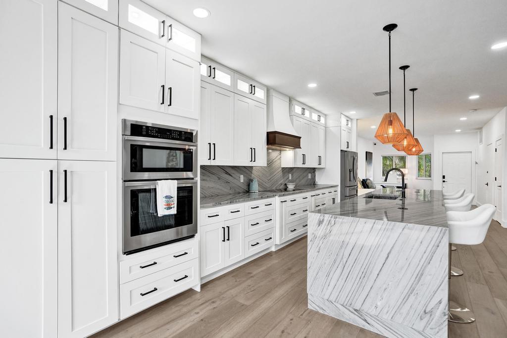 6800 Via Regina Boca Raton, FL 33433 - Photo 12 of 58 a kitchen with white cabinets and stainless steel appliances