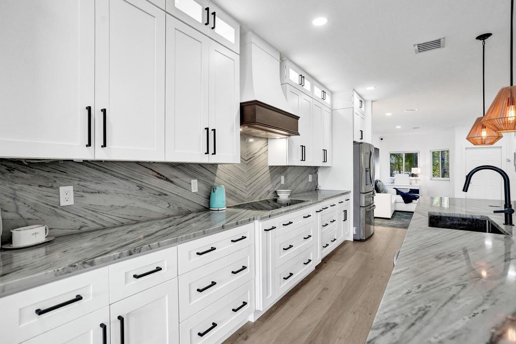 6800 Via Regina Boca Raton, FL 33433 - Photo 13 of 58 a large kitchen with stainless steel appliances granite countertop a lot of counter space and wooden floors