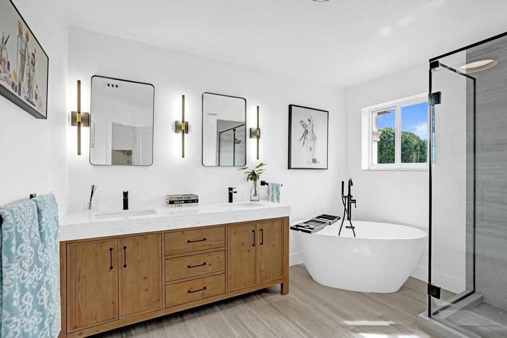 6800 Via Regina Boca Raton, FL 33433 - Photo 29 of 58 a bathroom with a double vanity sink a mirror a bathtub and shower