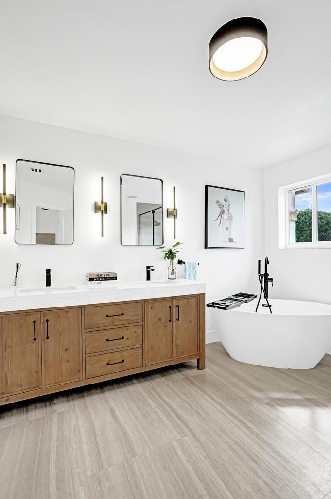6800 Via Regina Boca Raton, FL 33433 - Photo 30 of 58 a spacious bathroom with double vanity sink a two mirror a window and a bathtub