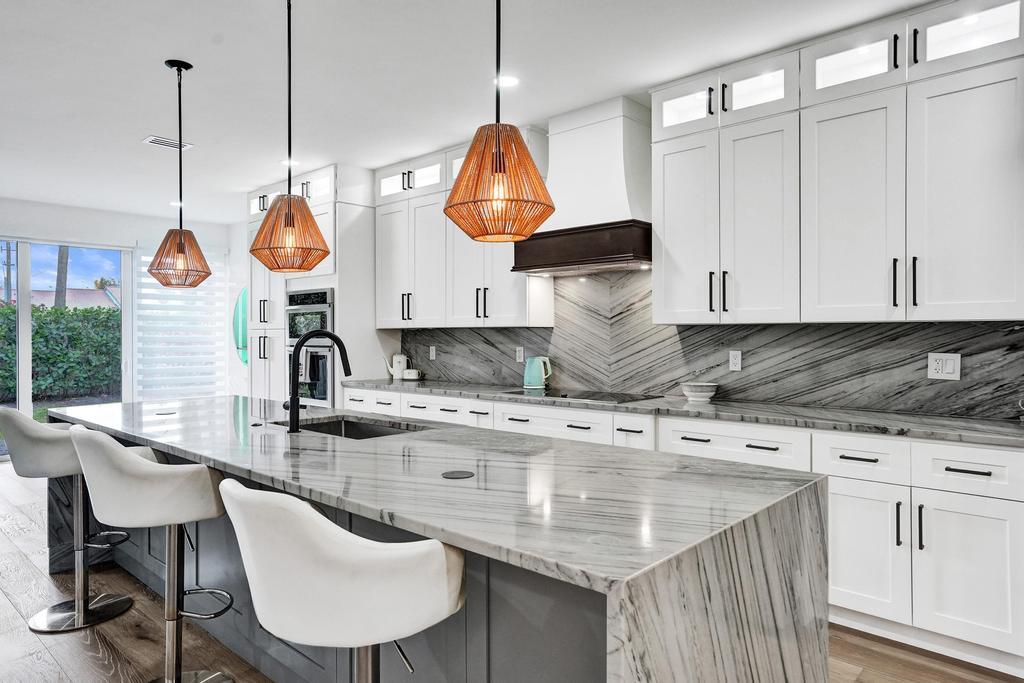 6800 Via Regina Boca Raton, FL 33433 - Photo 8 of 58 a kitchen with stainless steel appliances granite countertop a sink a stove and chairs