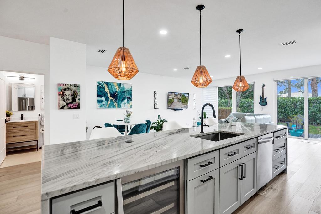 6800 Via Regina Boca Raton, FL 33433 - Photo 10 of 58 a kitchen with kitchen island granite countertop a stove a sink a center island a large window and cabinets