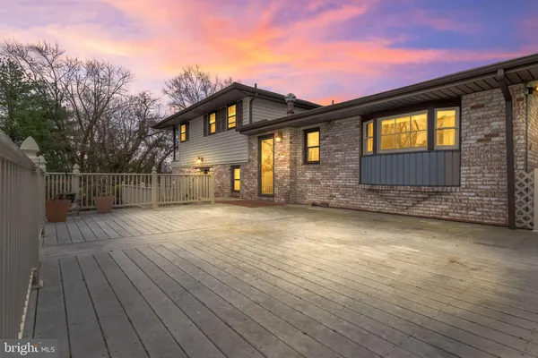 a view of a big house with a big yard and large trees