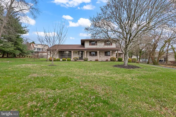 a view of a house with a big yard and large trees