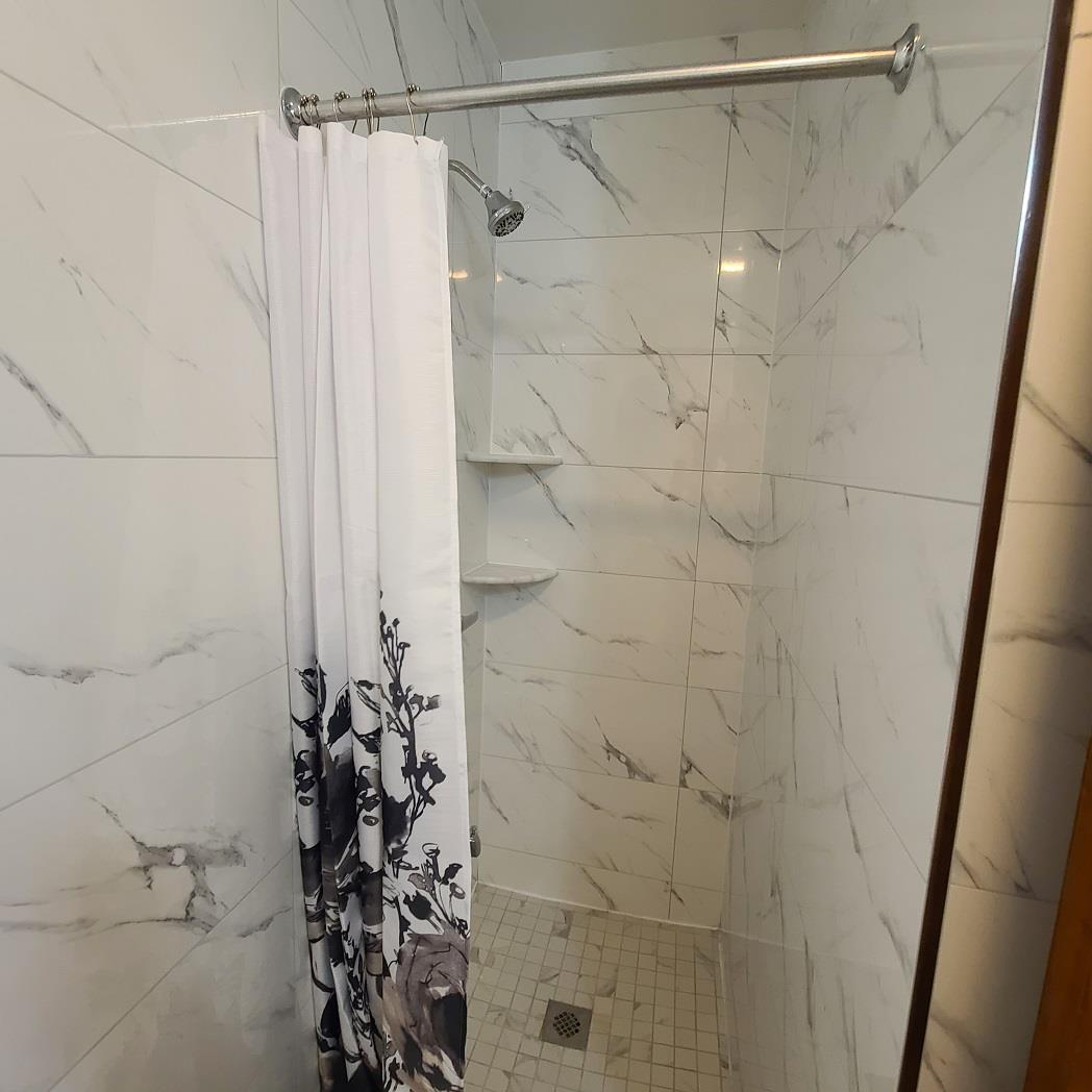 85-10 165th Street Queens, NY 11432 - Photo 14 of 24 a bathroom with a shower